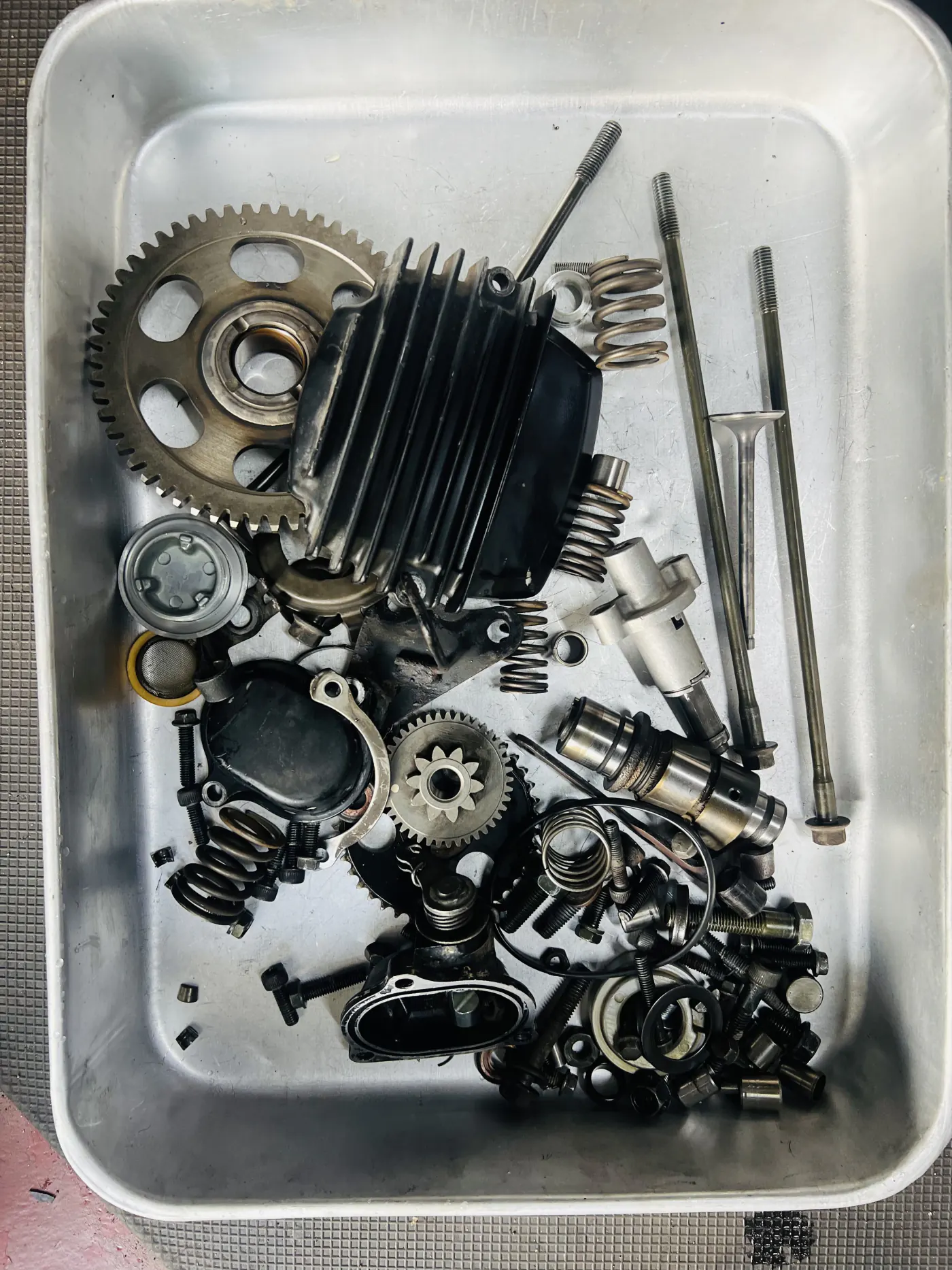 Disassembled motorcycle engine and transmission parts arranged for inspection