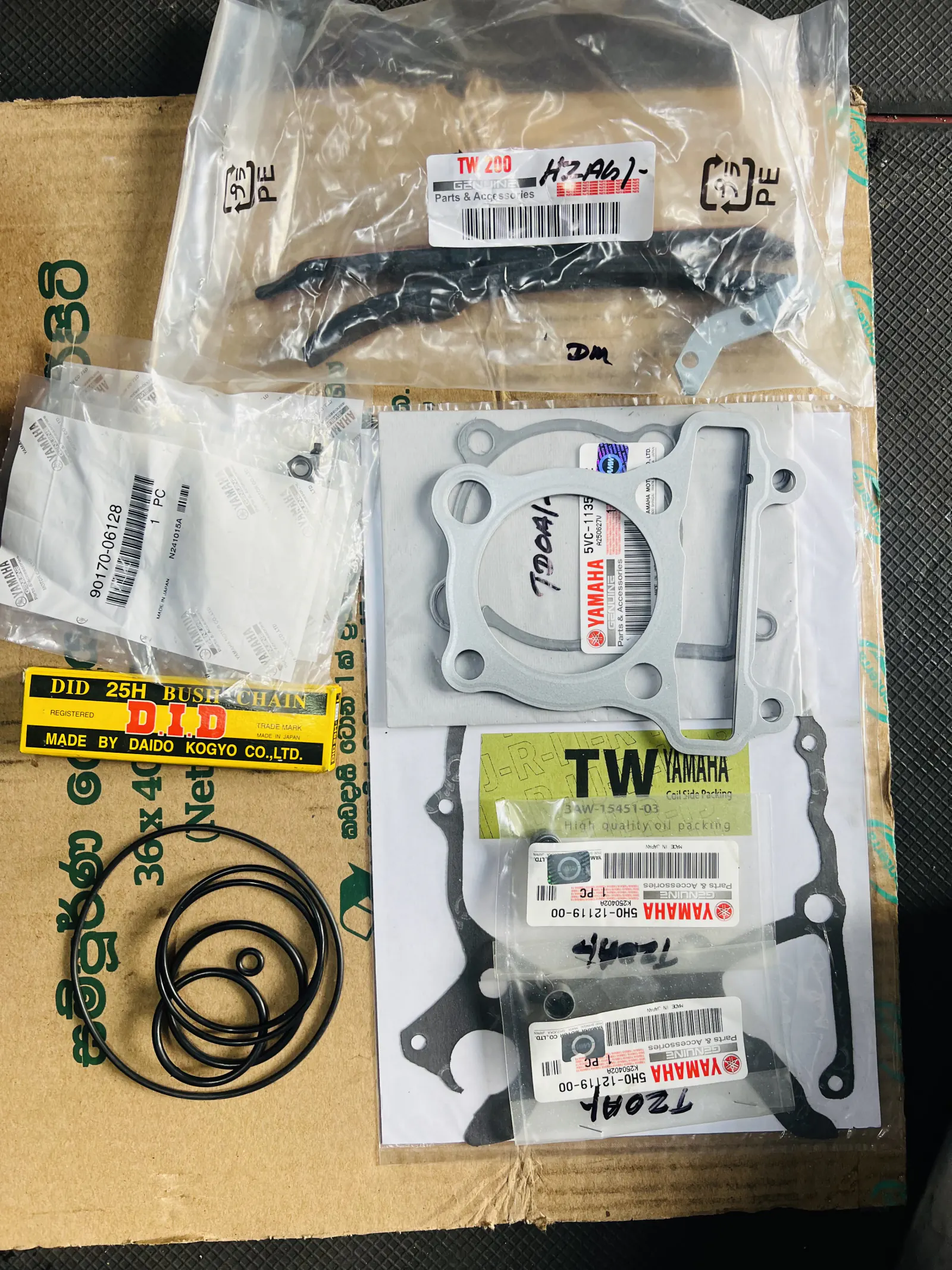 Yamaha TW engine gaskets, seals and service parts arranged on a workbench